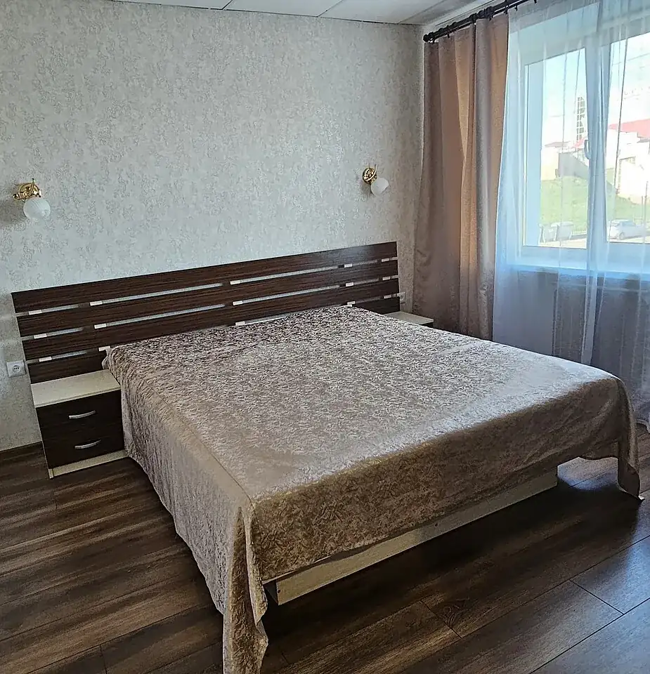 Dormitorio con cama de matrimonio y mesilla, en una vivienda como las que vaciamos en Gràcia