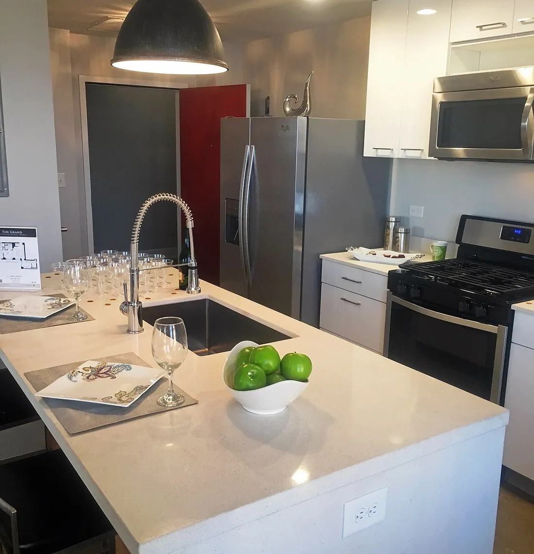 Cocina abierta con isla, nevera americana y horno, en una vivienda como las que vaciamos en Nou Barris