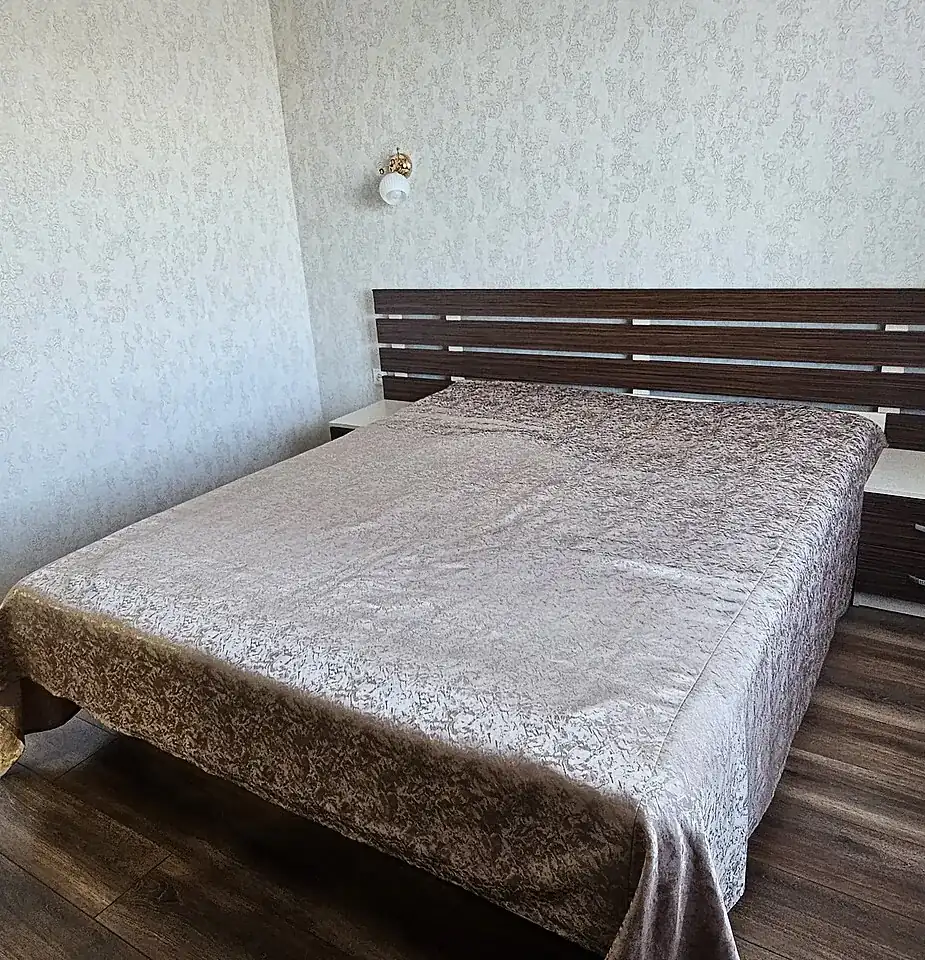 Dormitorio con cama de matrimonio y cabecero de madera, en una vivienda como las que vaciamos en el Prat de Llobregat