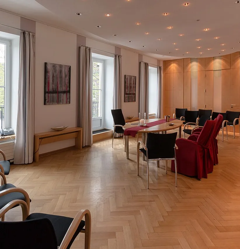 Sala amplia con mesas, sillas y suelo de espiga, en una vivienda como las que vaciamos en Montcada i Reixac